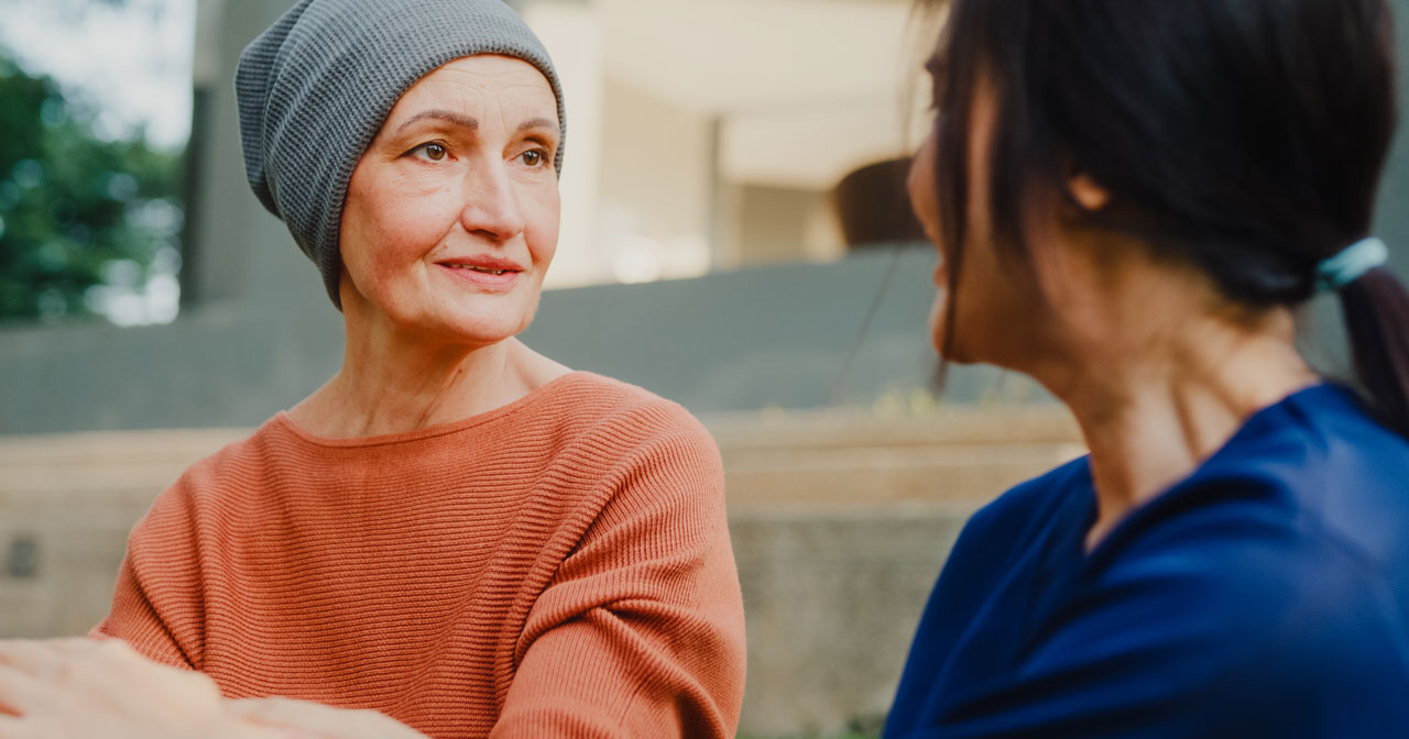 Photo of two women outdoors discussing chemotherapy side effects